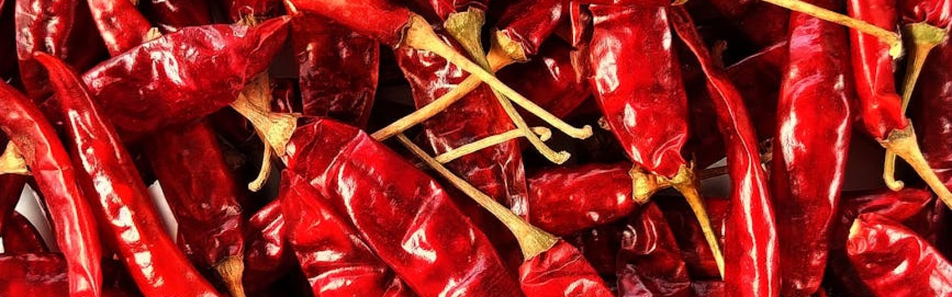 High-resolution image of dried red chili peppers in a pile, showcasing texture and detail.